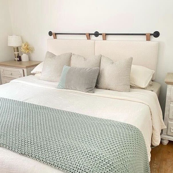 A dressed Sealy bed with a cream bedding teal throw 