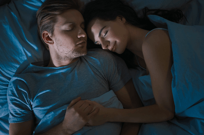 Closeup of man and woman sleeping next to each other and cuddling
